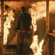Michael Myers stands on the burning porch of Laurie Strode's house in Halloween Kills.